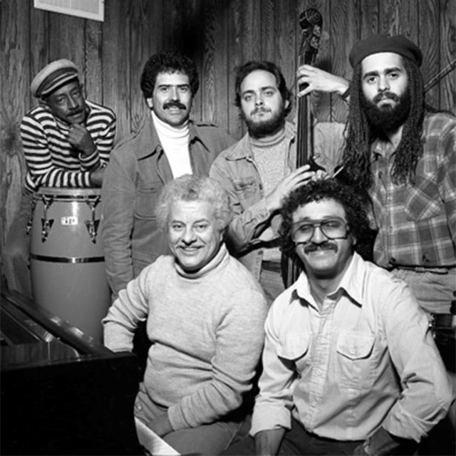 Latin Percussion Ensemble Project: Carlos “Patato” Valdes, Johnny “Dandy” Rodríguez, Andy Gonzalez, and Alfredo de la Fé. Seated: Tito Puente and Edy Martínez. Photo by Martin Cohen.