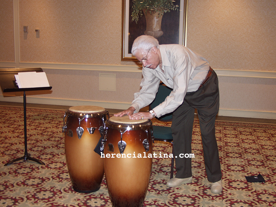 Johnny Pacheco inclinado tocando conga