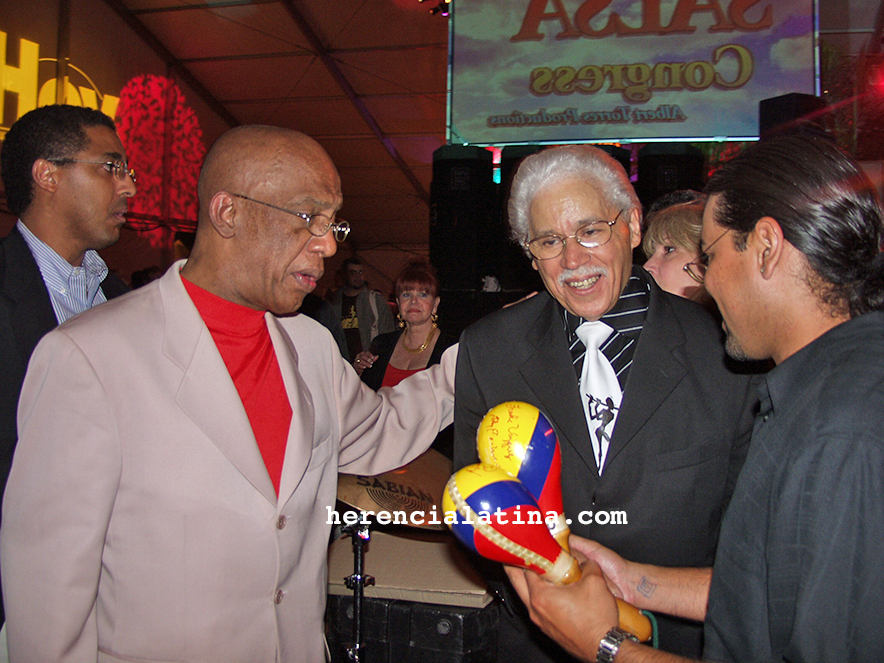 Roberto Roena conversando con Johnny Pacheco, entre el público