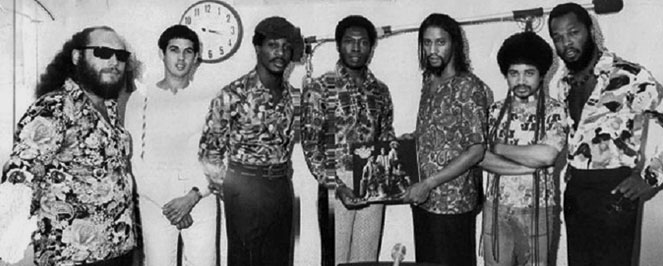 Estación de radio de Los Angeles, 1973. Fudgie Kae, Omar Mesa, Carlos Wilson, DJ de la estación de radio de Los Angeles (sin identificar), Claude “Coffee” Cave, Neftali Santiago, y Ric Wilson.